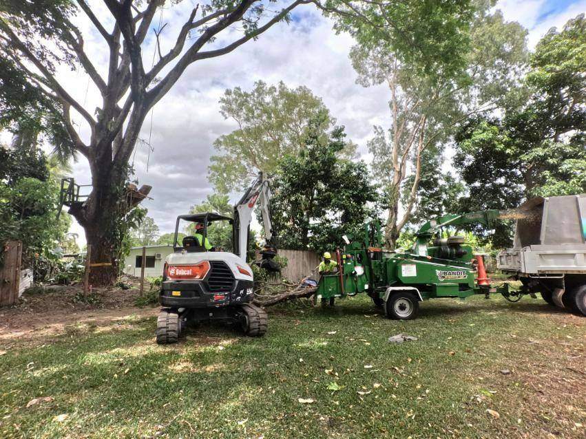 Excavator and chipper set up in a yard