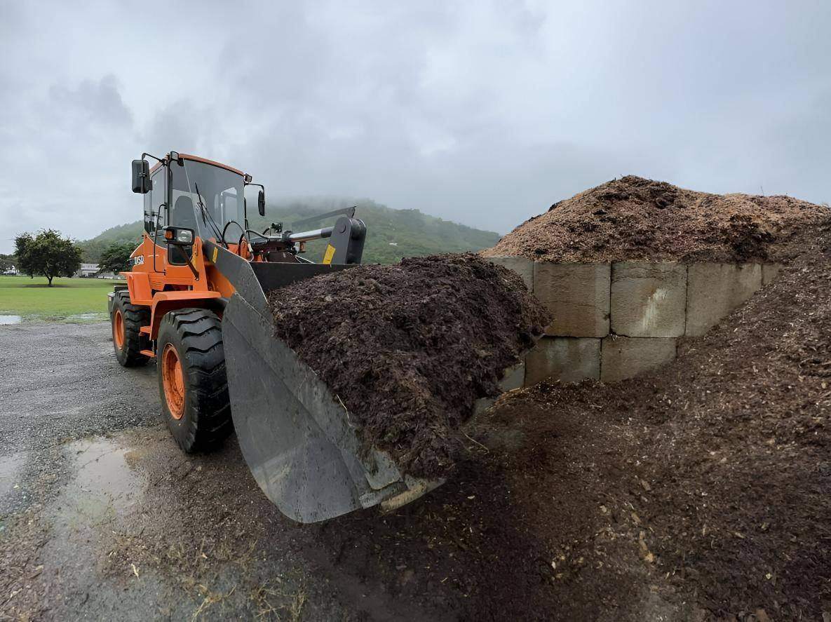 Loader moving mulch into a truck